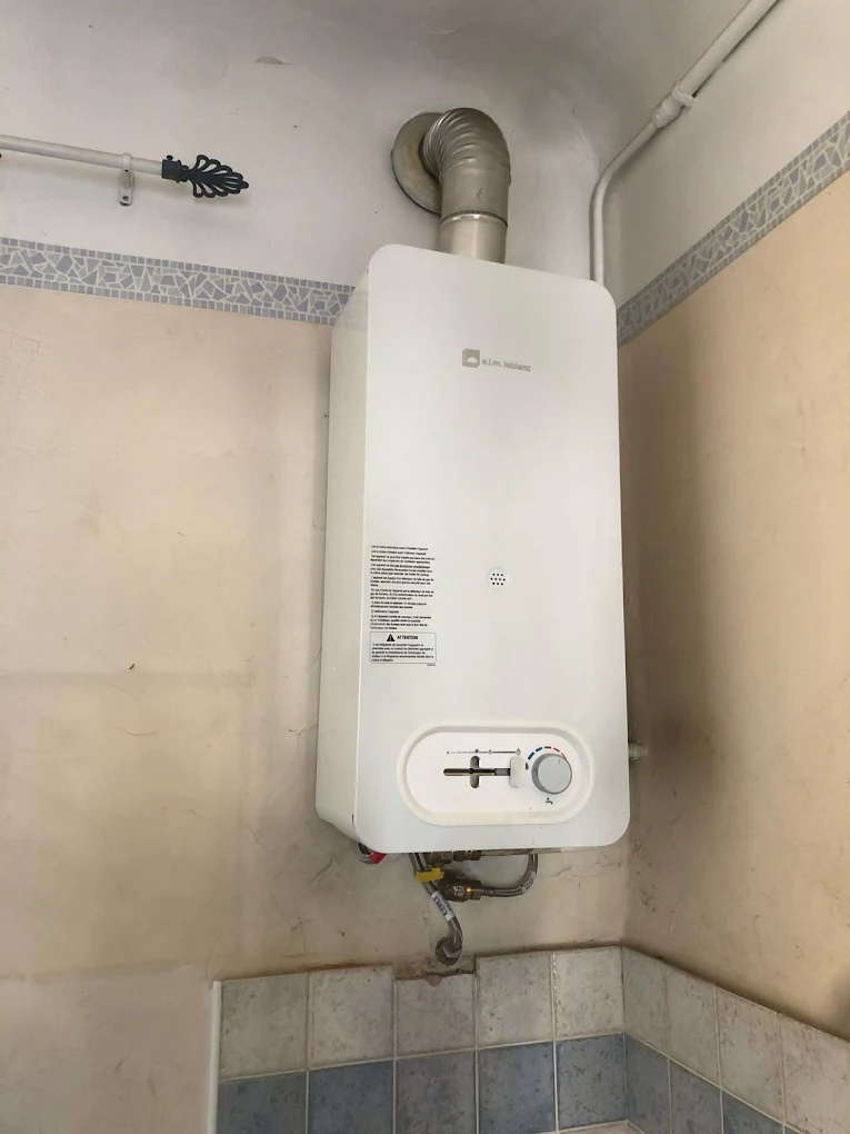 Chauffe-eau gaz elm.leblanc installé en salle de bain avec conduit d’évacuation