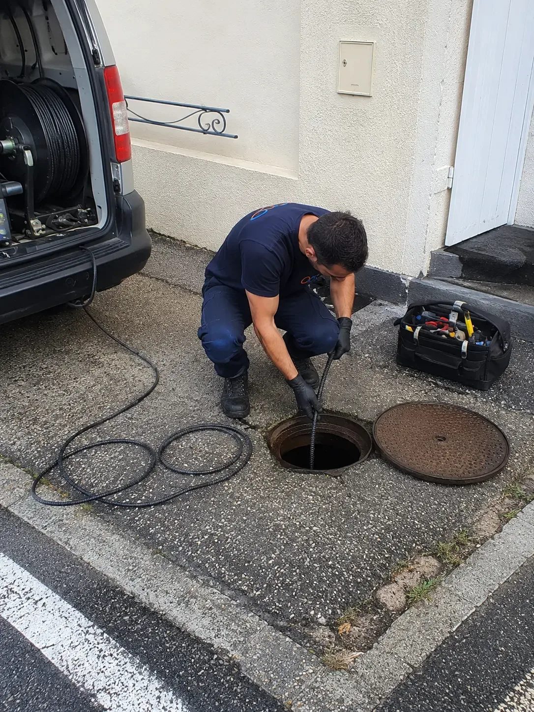 Technicien débouchant un regard d’assainissement au furet électrique